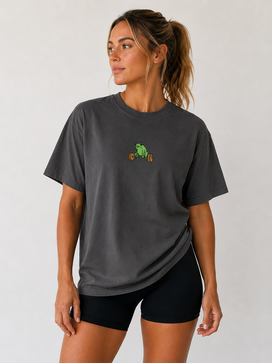 Woman wearing dark gray Global Fitness Co. oversized tee with embroidered frog fitness logo